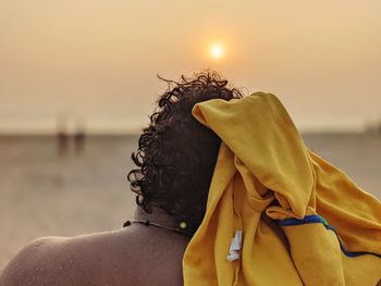 Portrait of woman on beach against sky during sunset