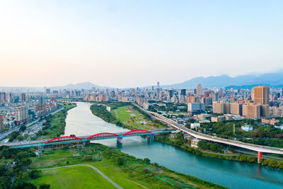 High angle view of river amidst buildings in city against clear sky