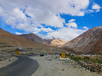 Scenic view of road by mountains against sky