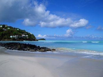 Scenic view of beach against blue sky