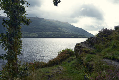 Scenic view of sea and mountains against sky