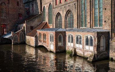 Arch bridge over river amidst buildings in city