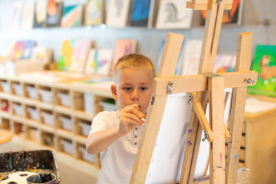 Boy painting at classroom