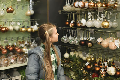 Rear view of woman standing by christmas tree