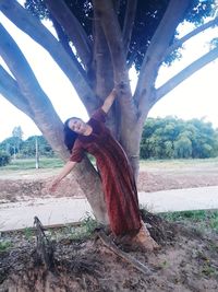 Man standing by tree on field against sky