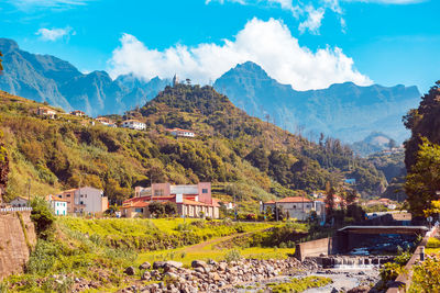 Scenic view of townscape and mountains against sky