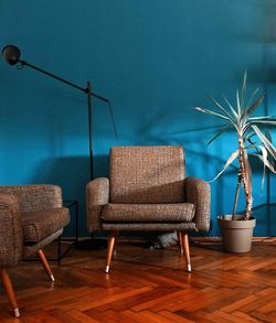 Chairs and tables against blue wall at home