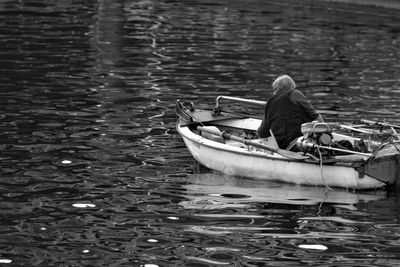Man sitting on boat sailing in lake