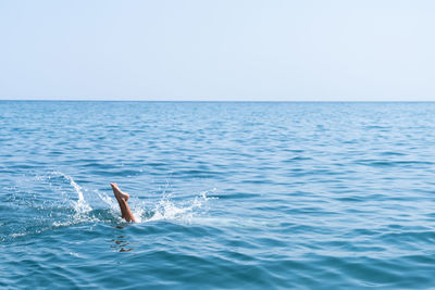 Fun on the seashore, the child jumps into the water, dives into the water of the ocean. splashes