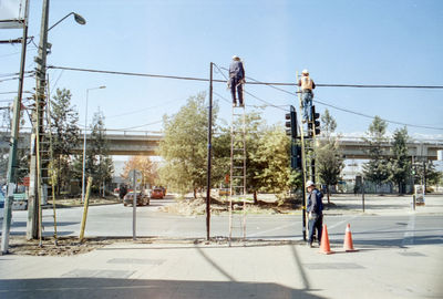 People working on construction site against sky in city