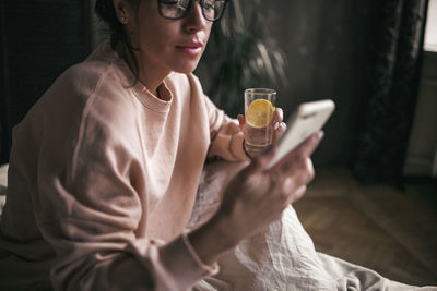 Midsection of a woman drinking glass