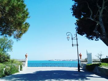 Street by swimming pool against clear blue sky