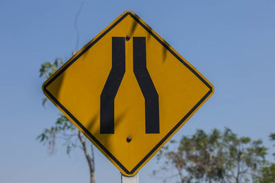 Road sign against clear blue sky