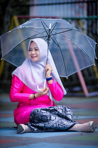 Rear view of woman holding umbrella