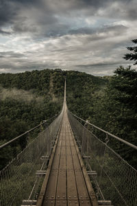 Footbridge over land against sky