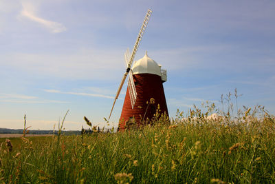 Traditional windmill on field against sky