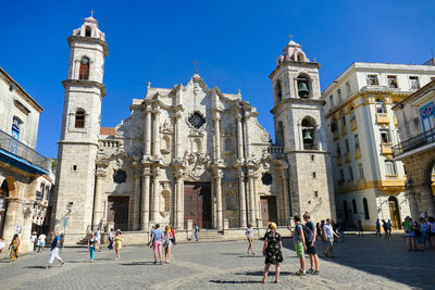 Group of people in front of historic building in city