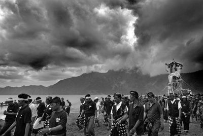 Group of people on mountain road against sky