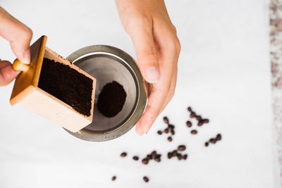 High angle view of hand holding coffee cup