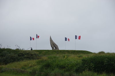 Flags on field against sky