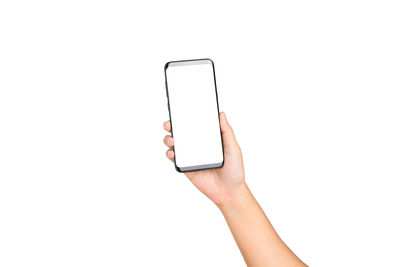 Cropped hand of woman holding mobile phone against white background