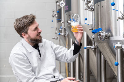 Side view of scientist examining chemical in laboratory