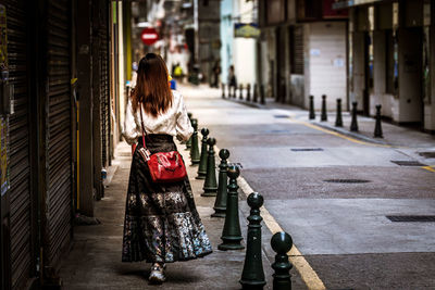 Rear view of woman standing in city