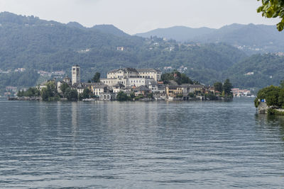 Scenic view of lake by buildings against sky