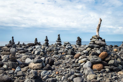 Stack of pebbles on beach against sky