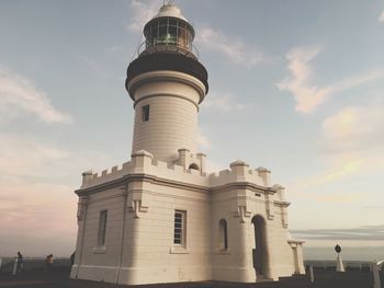 Low angle view of lighthouse against buildings