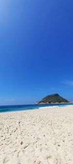 Scenic view of beach against clear blue sky