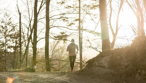 Rear view of man walking in forest