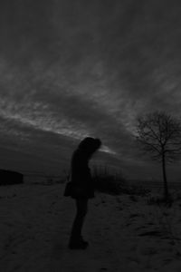 Silhouette of bare tree against cloudy sky