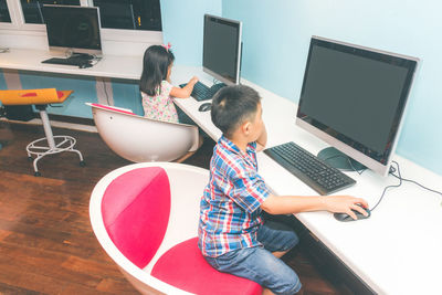 Side view of boy using mobile phone on table