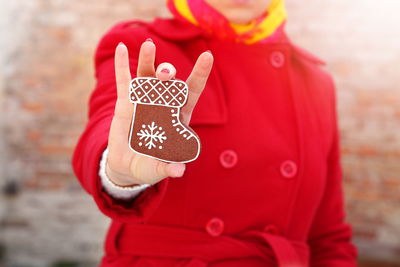 Midsection of woman holding gingerbread cookie during christmas