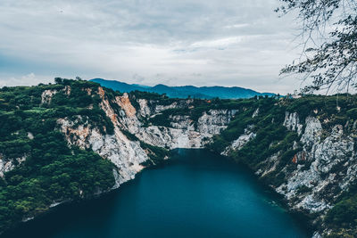 Scenic view of river against cloudy sky