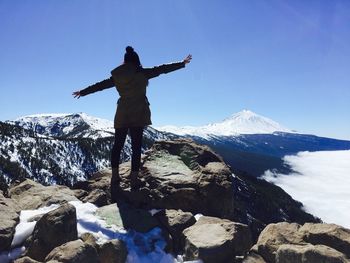 Low angle view of man standing on mountain against sky