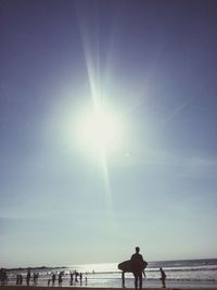 Silhouette surfer standing on beach