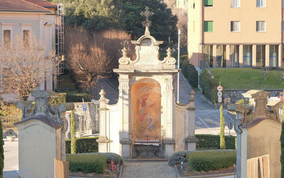 Statue amidst trees and buildings in city