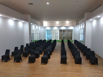 Empty chairs and tables in illuminated room