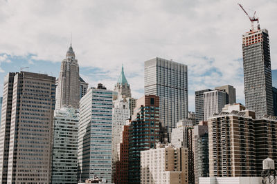 Buildings in city against cloudy sky