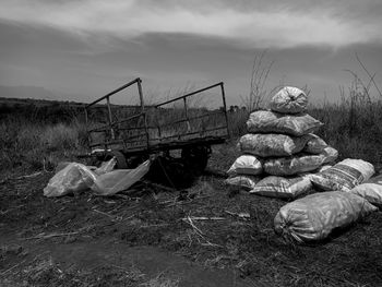 Stack of abandoned stones on field against sky