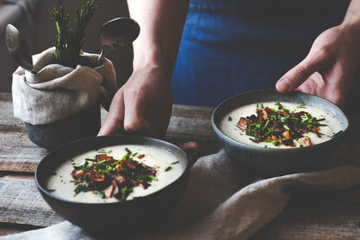 Midsection of man holding bowl on table
