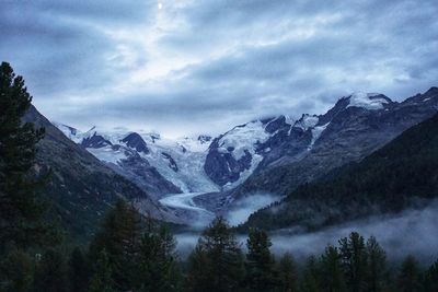 Scenic view of snowcapped mountains against cloudy sky