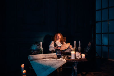 Portrait of young woman sitting on table