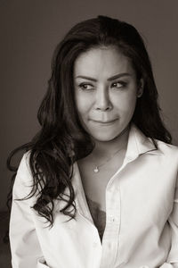 Portrait of young asian woman standing against wall