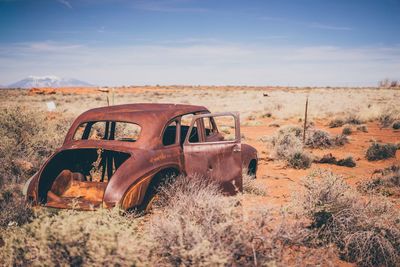 Abandoned truck on field against sky