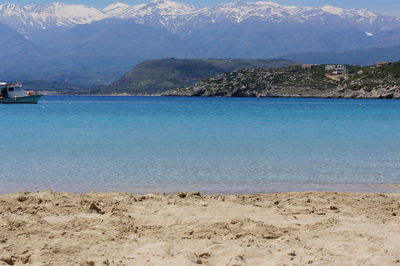 Scenic view of sea and mountains against sky