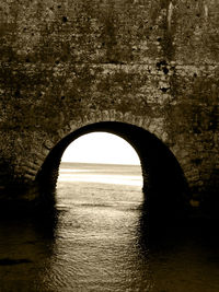 Arch bridge over sea against sky