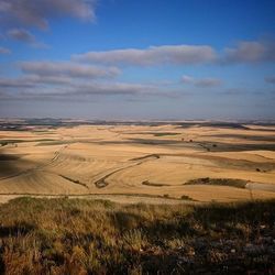 Scenic view of field against cloudy sky